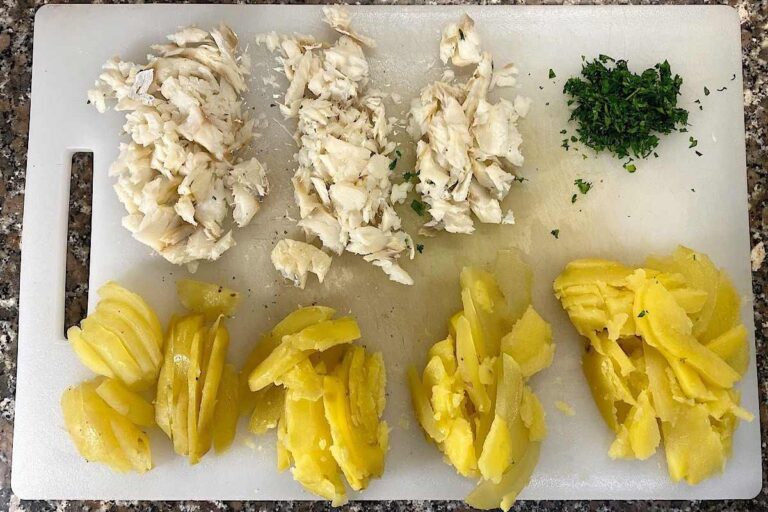 pezzi di baccalà patate e prezzemolo su vassoio bianco