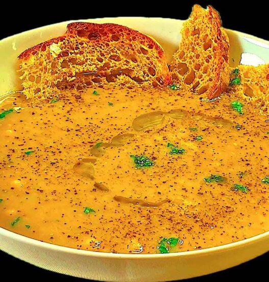 zuppa in piatto bianco con fette di pane