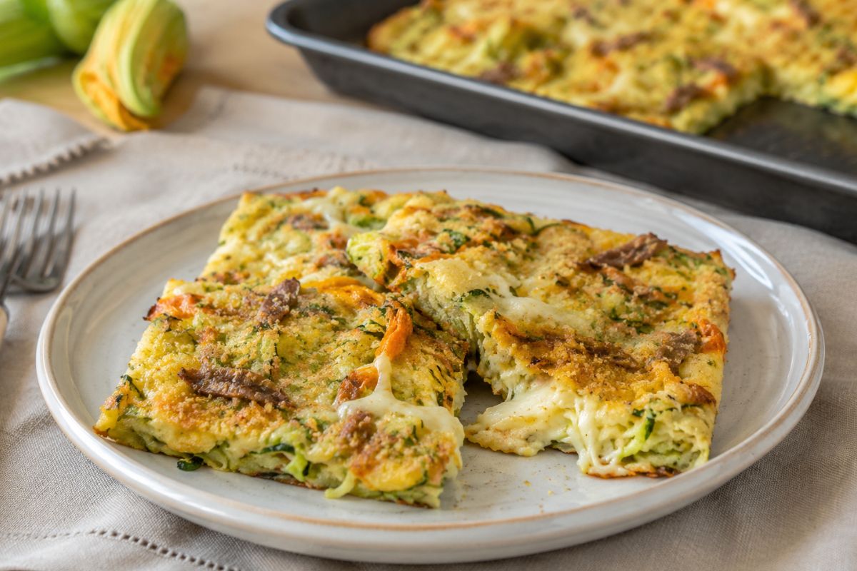 Provate a mettere fiori di zucca, alici e bufala sulla schiacciata di zucchine: non ne resterà nemmeno una fetta